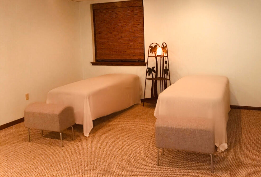 A massage room at CM Massotherapy with a candle being burned in the background.